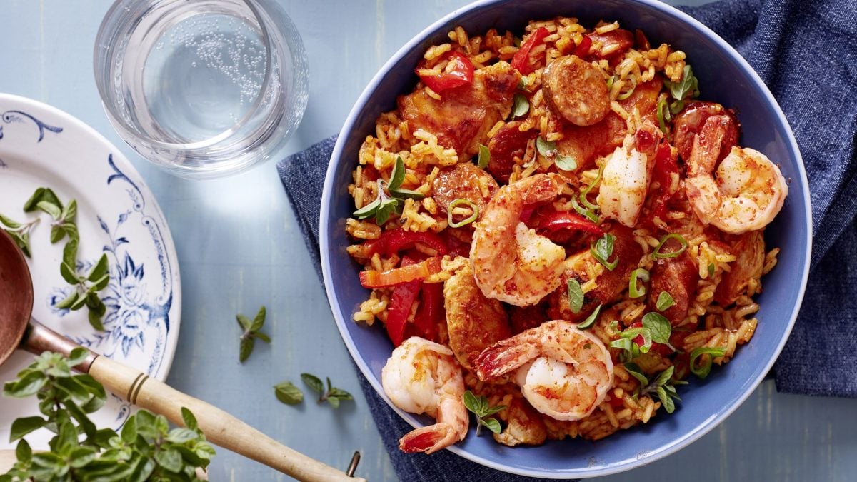 Das bunte Jambalaya steht angerichtet in einer Schüssel auf dem Tisch.