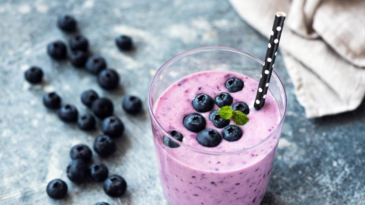 Blaubeer-Joghurt-Smoothie im Glas mit Strohhalm