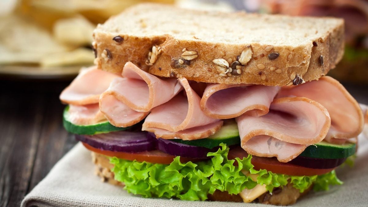 Puten-Sandwich mit knackigem Gemüse auf Körnerbrot mit Tomate, Gurke, Zwiebeln und Salat
