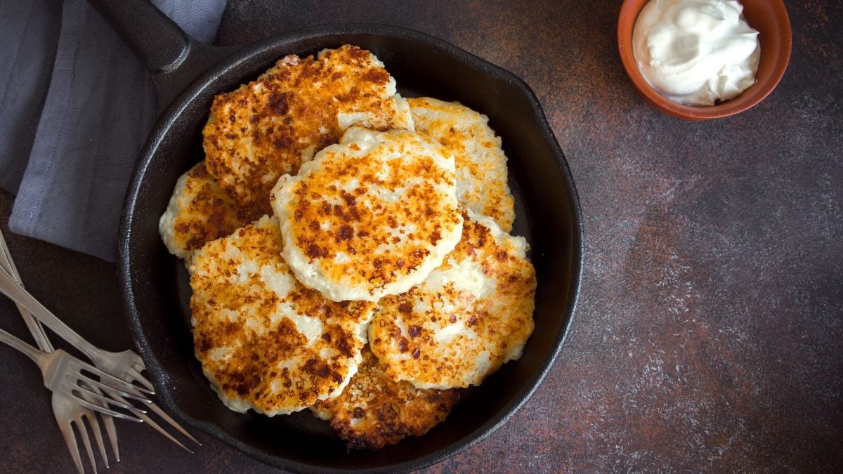 Vegetarisches Kohlrabi-Schnitzel mit selbstgemachtem Dip in Pfanne, daneben Schüssel mit Dip