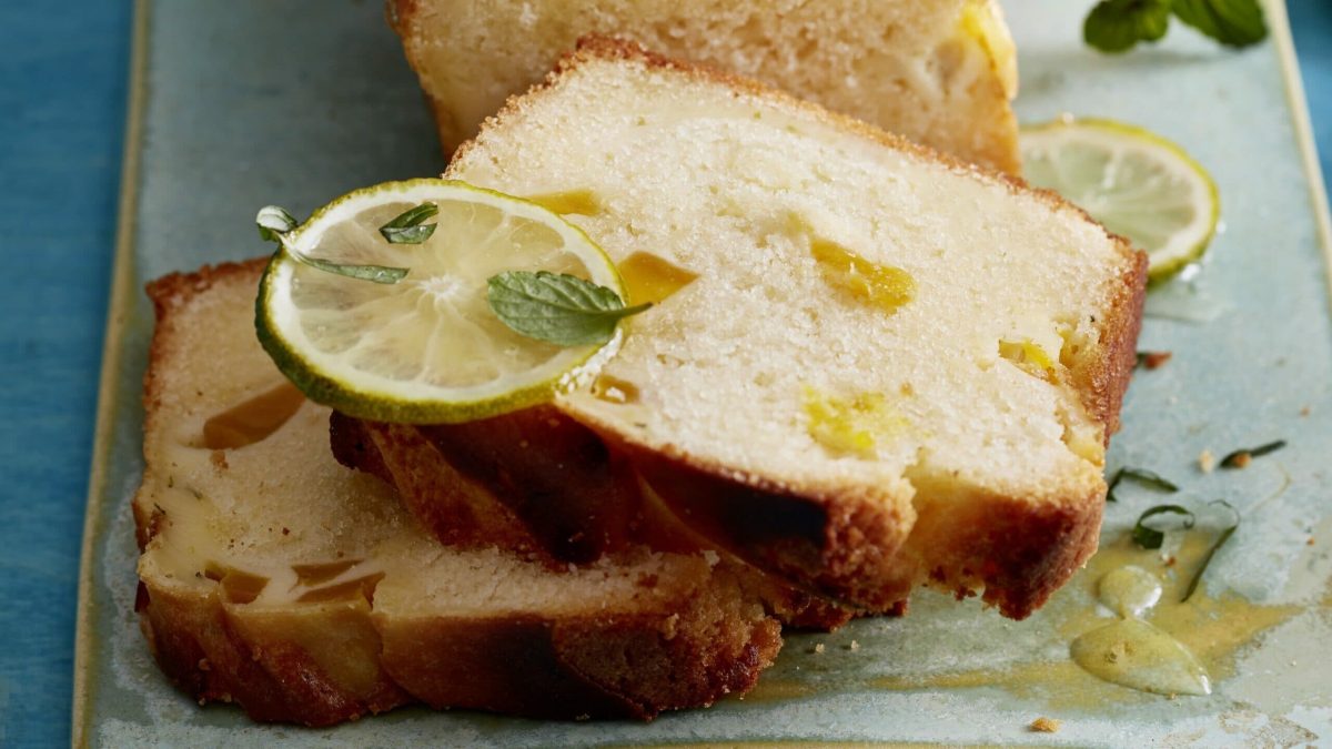 Mango-Schmand-Kastenkuchen mit Limette garniert auf blauer Platte