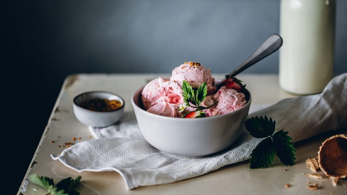 Erdbeer Frozen Yoghurt in weißer Keramikschale auf Holztisch