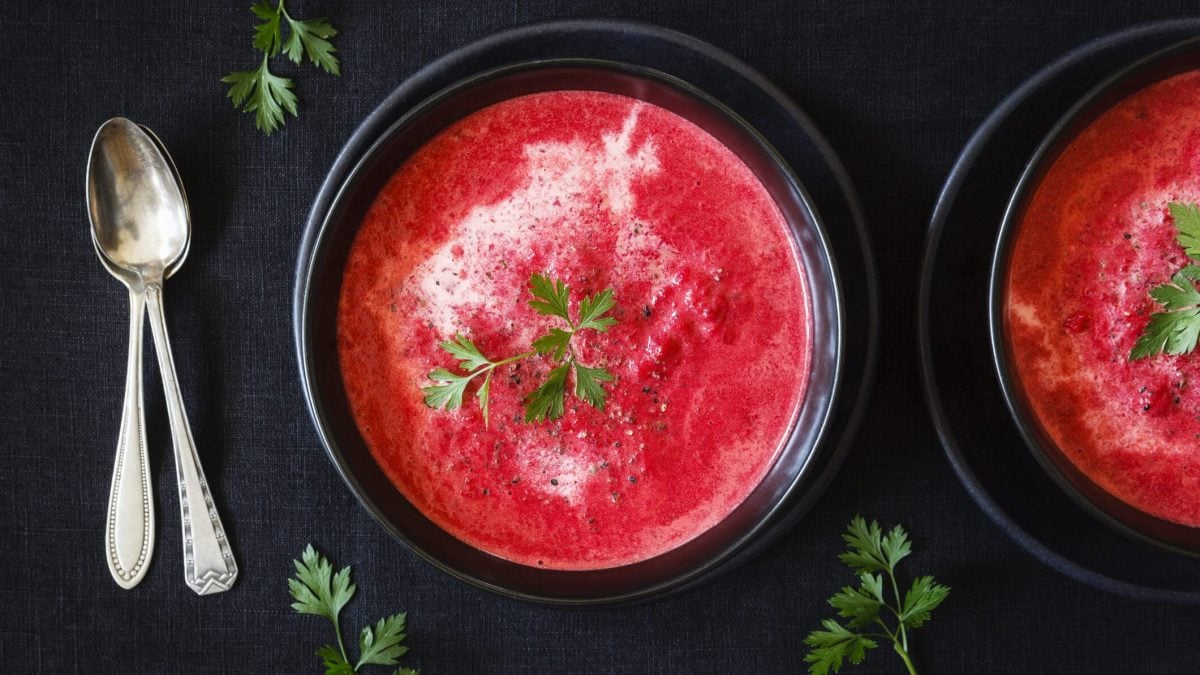 Süße Gazpacho mit Wassermelonen in schwarzen Schalen vor schwarzem Hintergrund