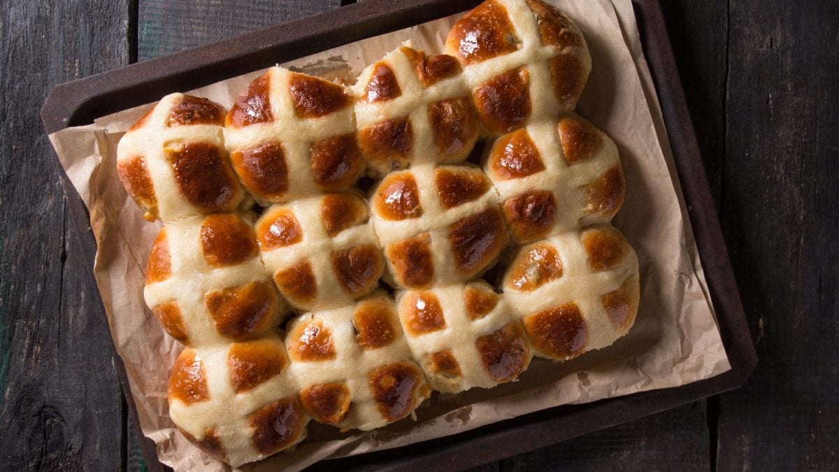 Fluffige Hot Cross Buns mit Aprikosenkonfitüre auf Blech mit Backpapier