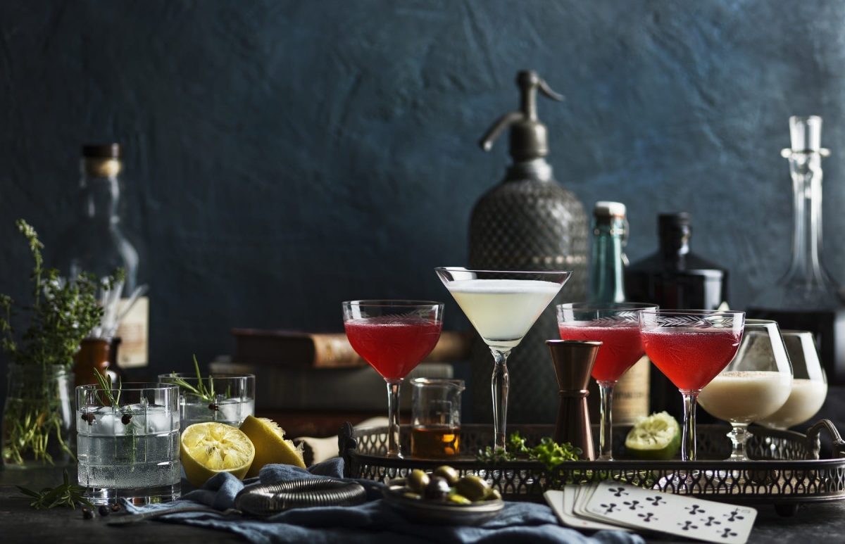 Verschiedene Drinks mit unterschiedlichem Alokoholgehalt auf dunklem Hintergrund haben unterschiedlich viele Kalorien.