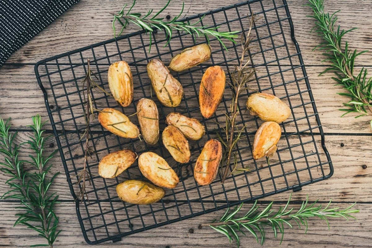 Knusprige Ofenkartoffeln auf Gitter mit Rosmarin.