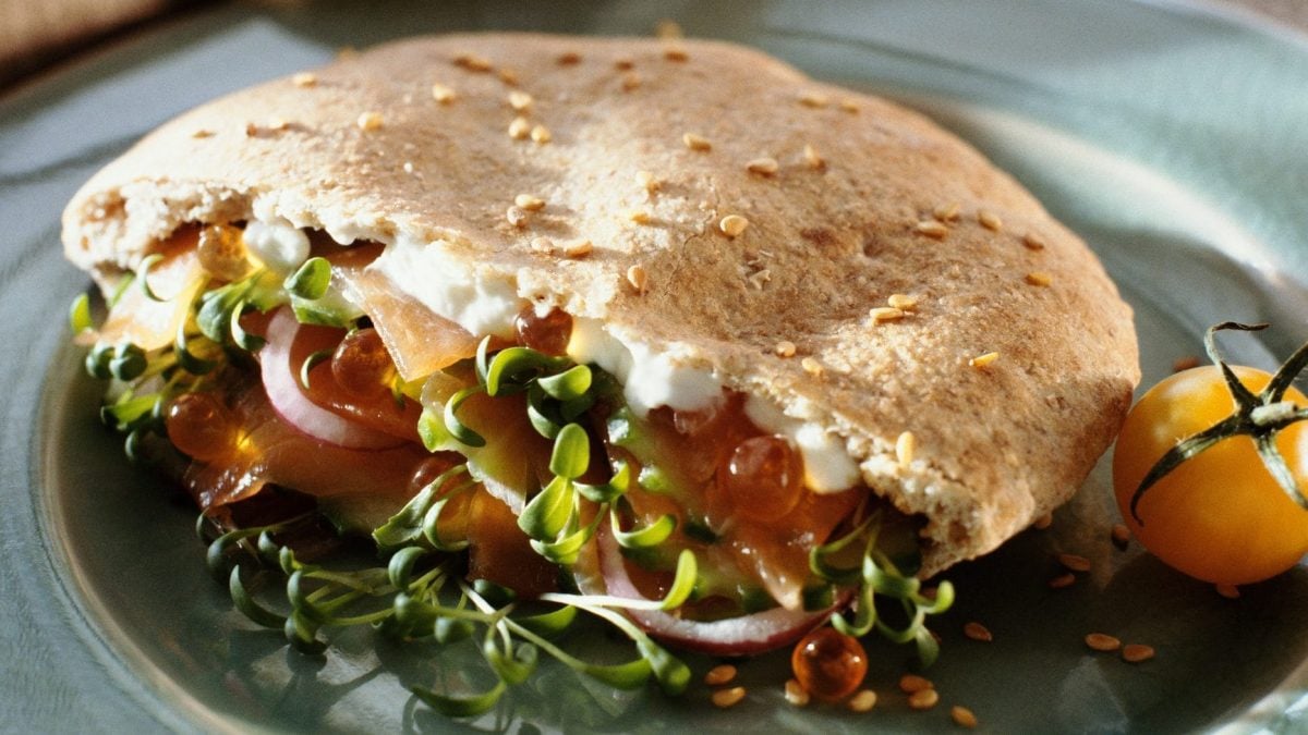 Veggie-Döner auf blauem Teller, daneben gelbe Tomate