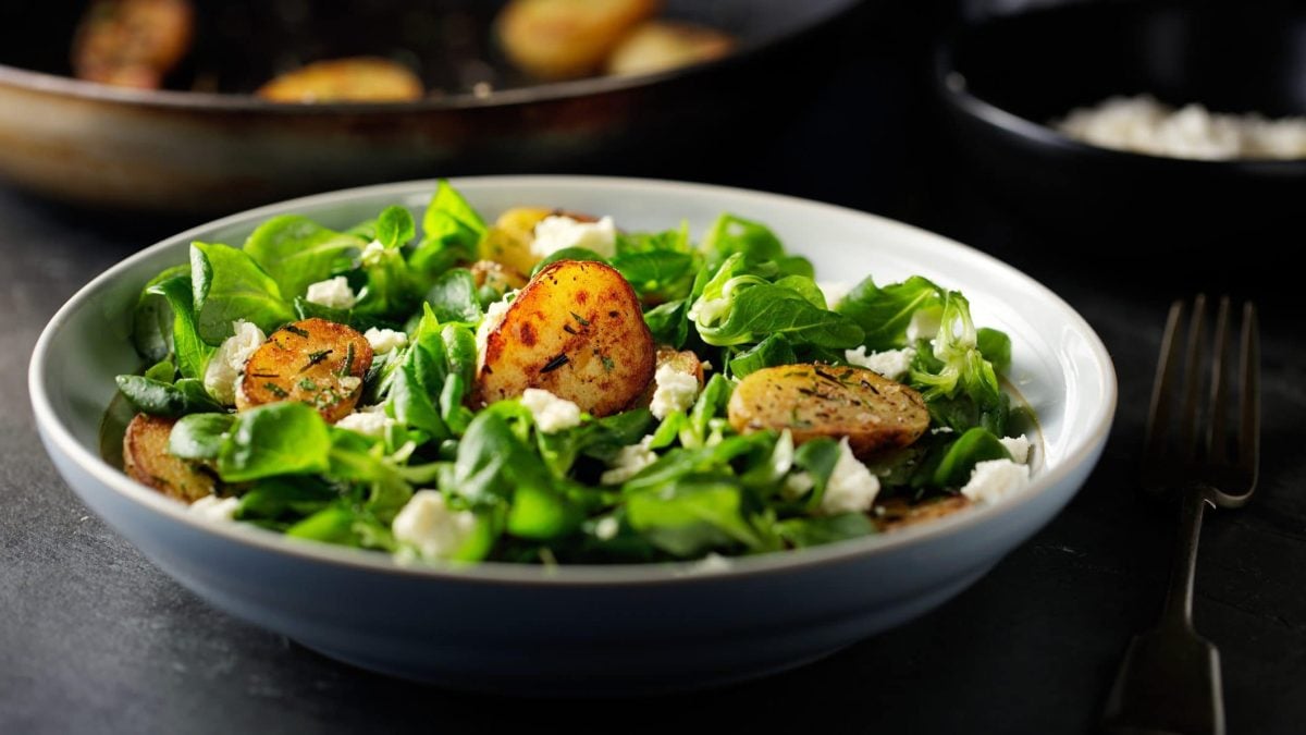 Feldsalat mit Röstkartoffeln und Feta in einer Schale.