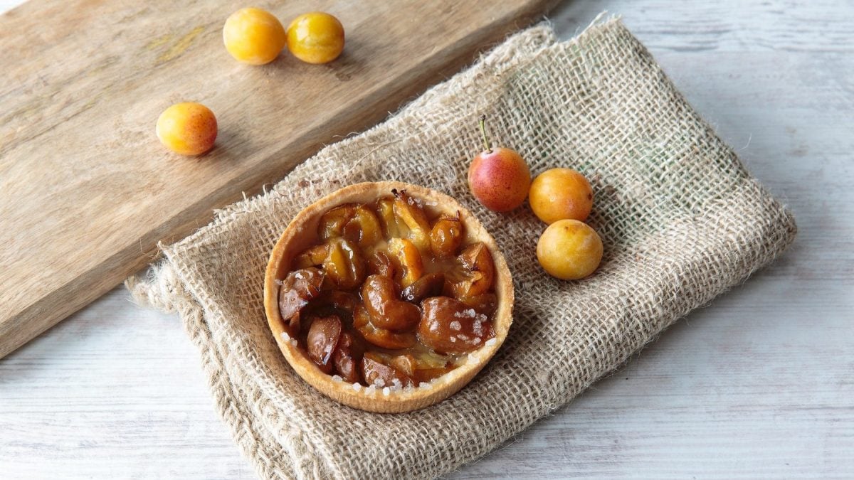 Mirabellenkuchen und Mirabellen mit Holzbrett und Leinentuch