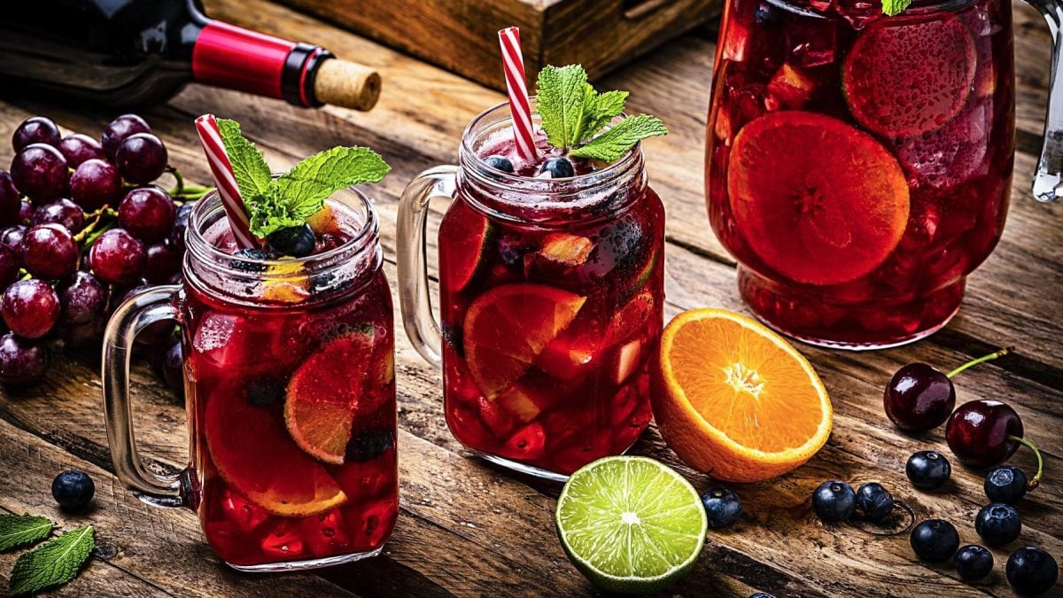 Erdbeer-Margarita Pop-Sicles auf grauer Unterlage, daneben Erdbeeren zum Tipsy Tuesday.