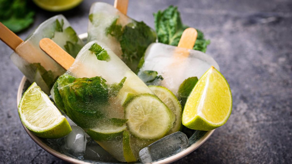 Gin Basil Smash am Stiel auf einem Teller mit Limetten