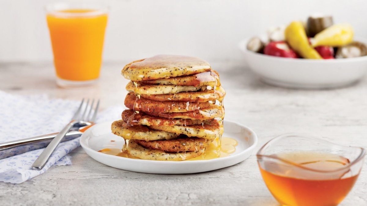 Pancakes mit Chiasamen und Agavensirup auf einem Teller.