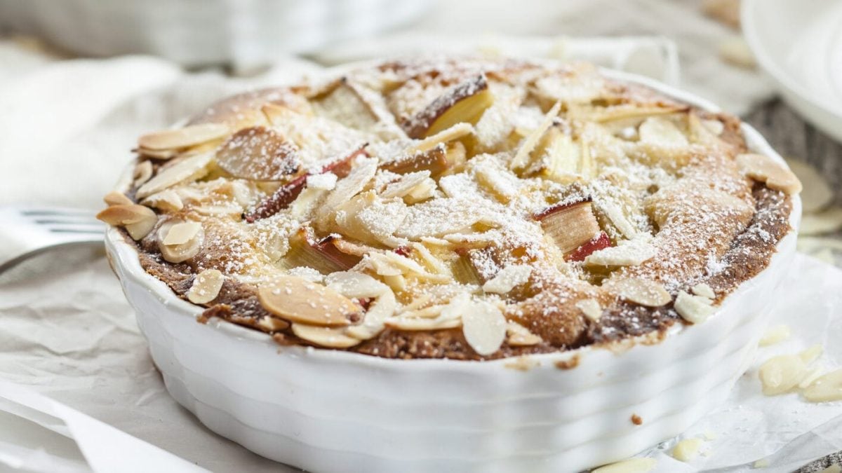 Ein Rhabarberkuchen mit Eierlikör und Mandeln in einer weißen Kuchenform