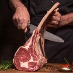 Fleisch wird mit Messer von Knochen getrennt.