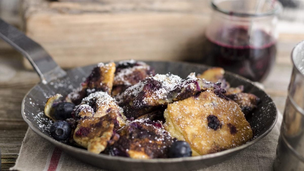 Kaiserschmarrn mit Blaubeeren in einer kleinen Pfanne.