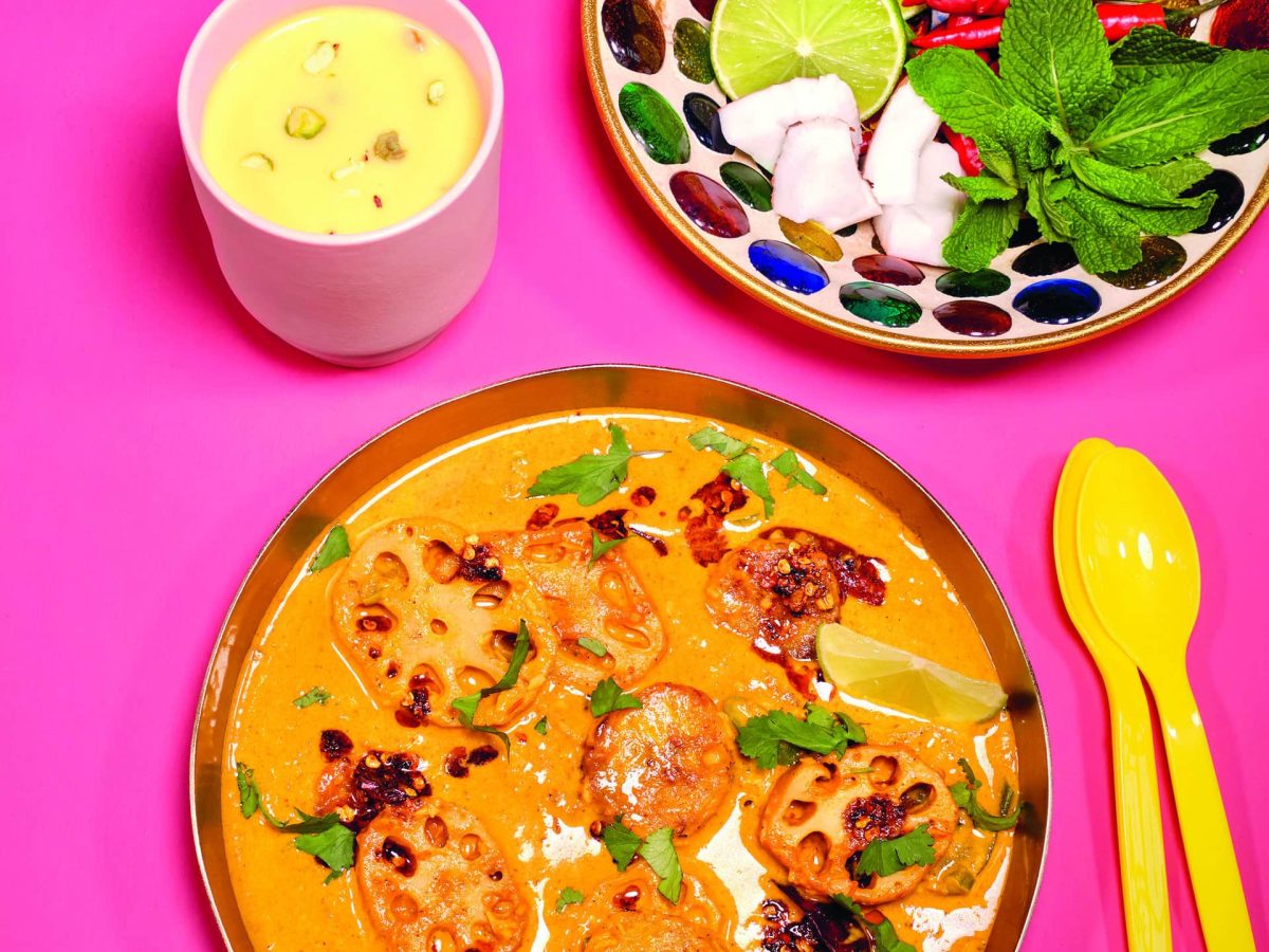 Das Lotuswurzel-Curry angerichtet in einer Schale, dazu als Topping Kokosflocken, Limette und Chilis.