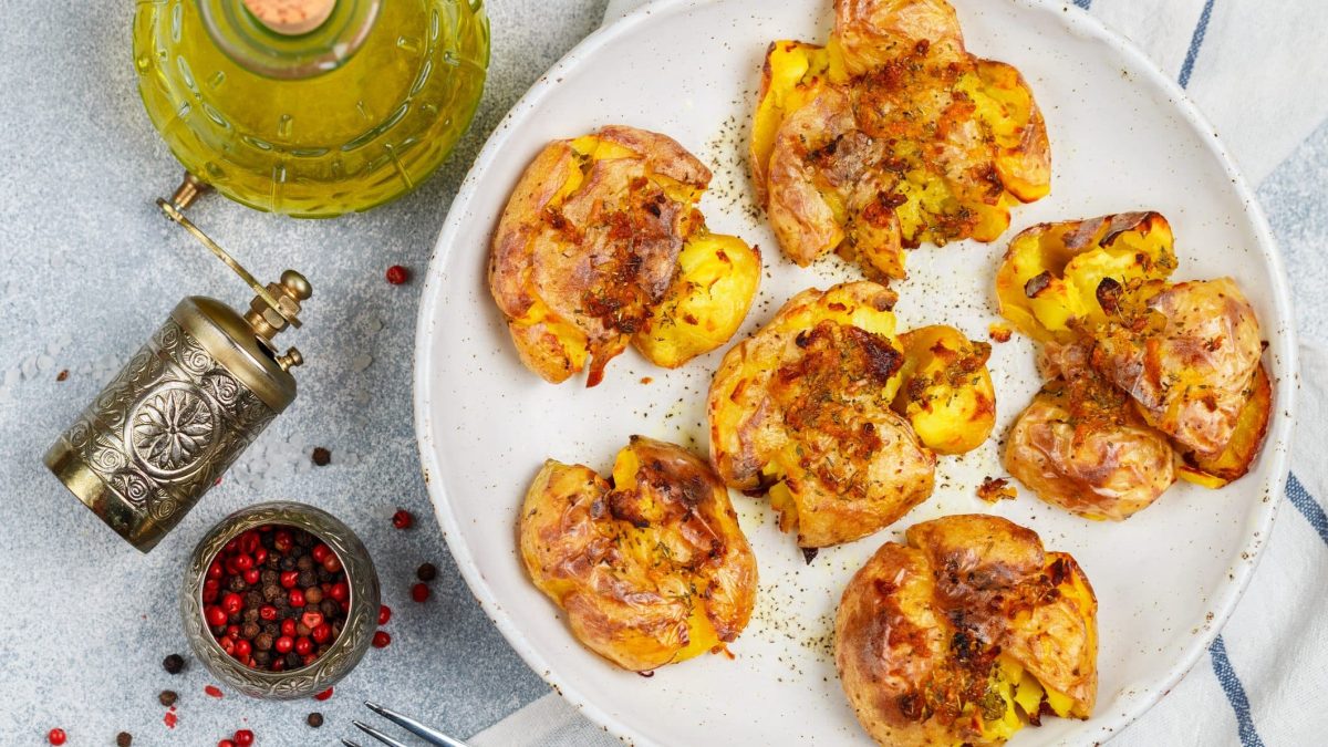 Smashed Potatoes auf weißem Teller