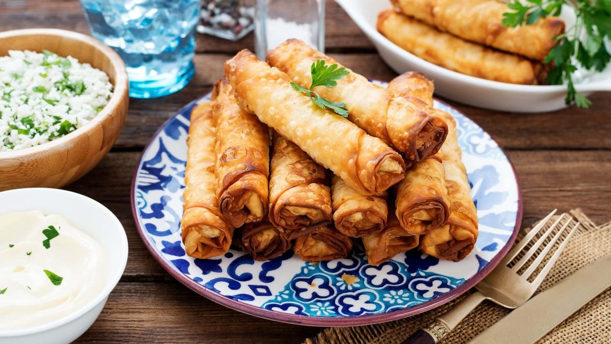 Auf einem otientalich anmutenden Teller lieben mehrere Börek mit Spinat-Feta-Fuellung.