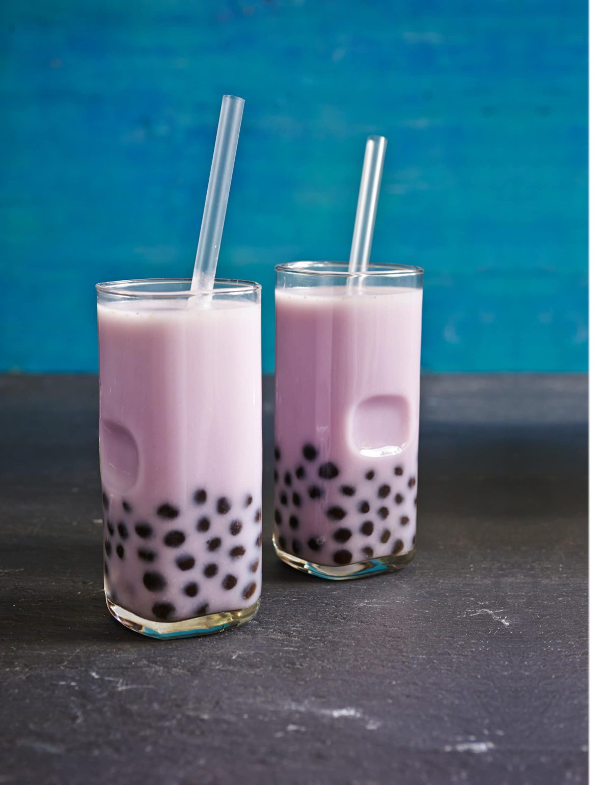 Der Taro-Bubble Tea ausgeschenkt in zwei hohen Gläsern mit Glasstrohhalm.