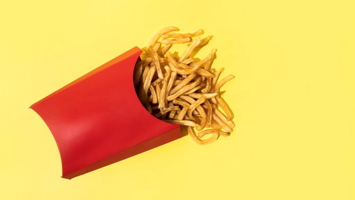 Eine rote Tüte mit Pommes auf einem weißen Untergrund