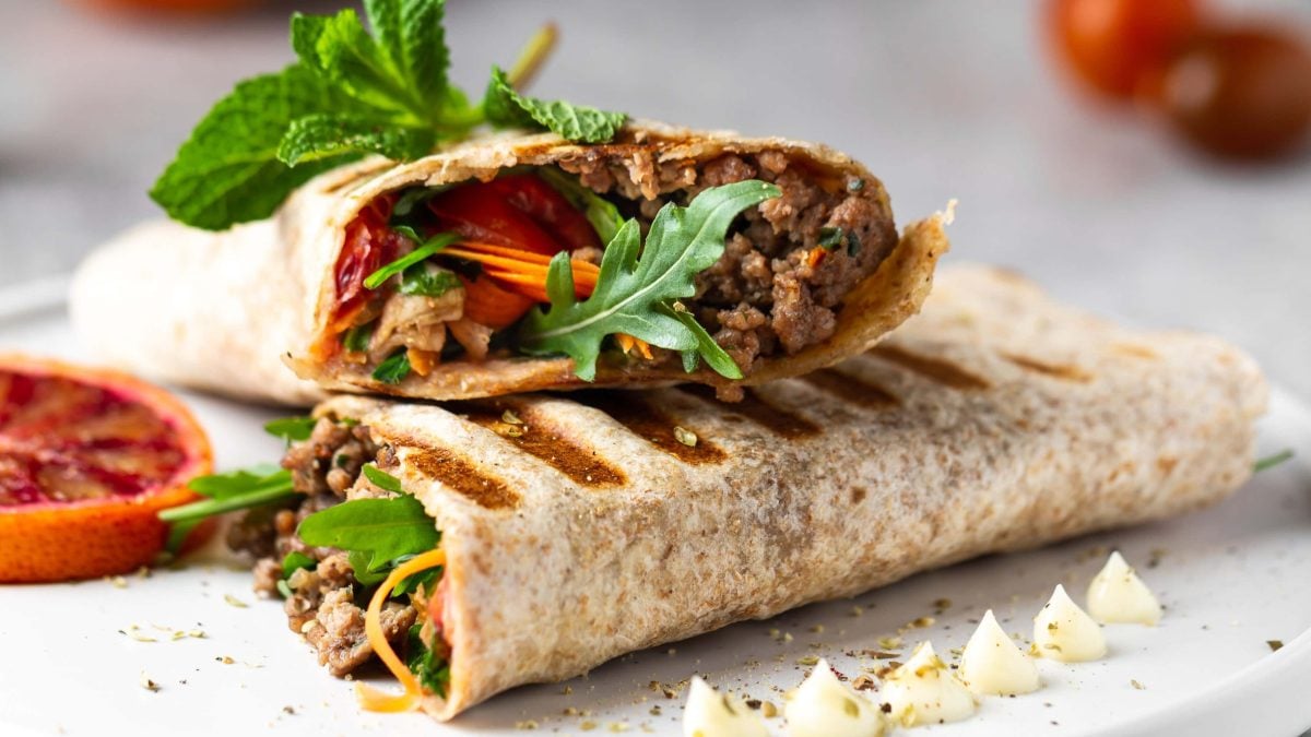 Zwei Wraps mit Hackfleisch, Rucola. Tomaten und Möhren.