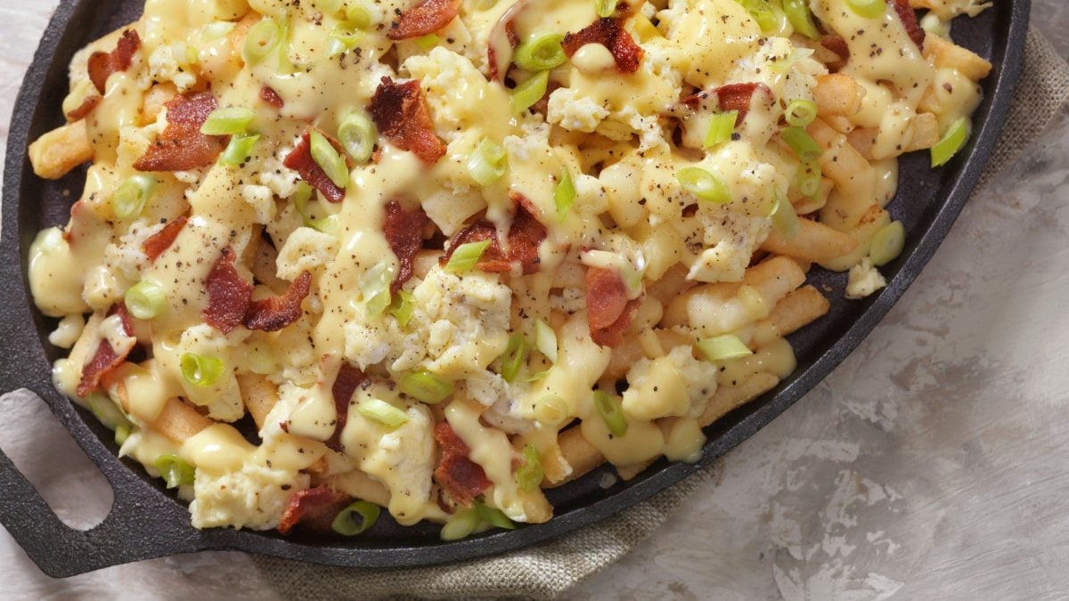 Poutine mit Frühstücks-Flair – Pommes belegt mit Sauce hollandaise, Käse, Bacon und Rührei