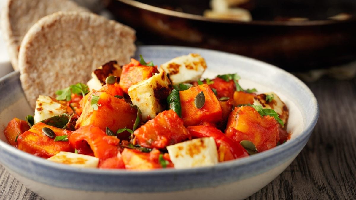 Unsere Kürbis-Halloumi-Pfanne wird in der Schale mit einem Stück Brot gereicht.