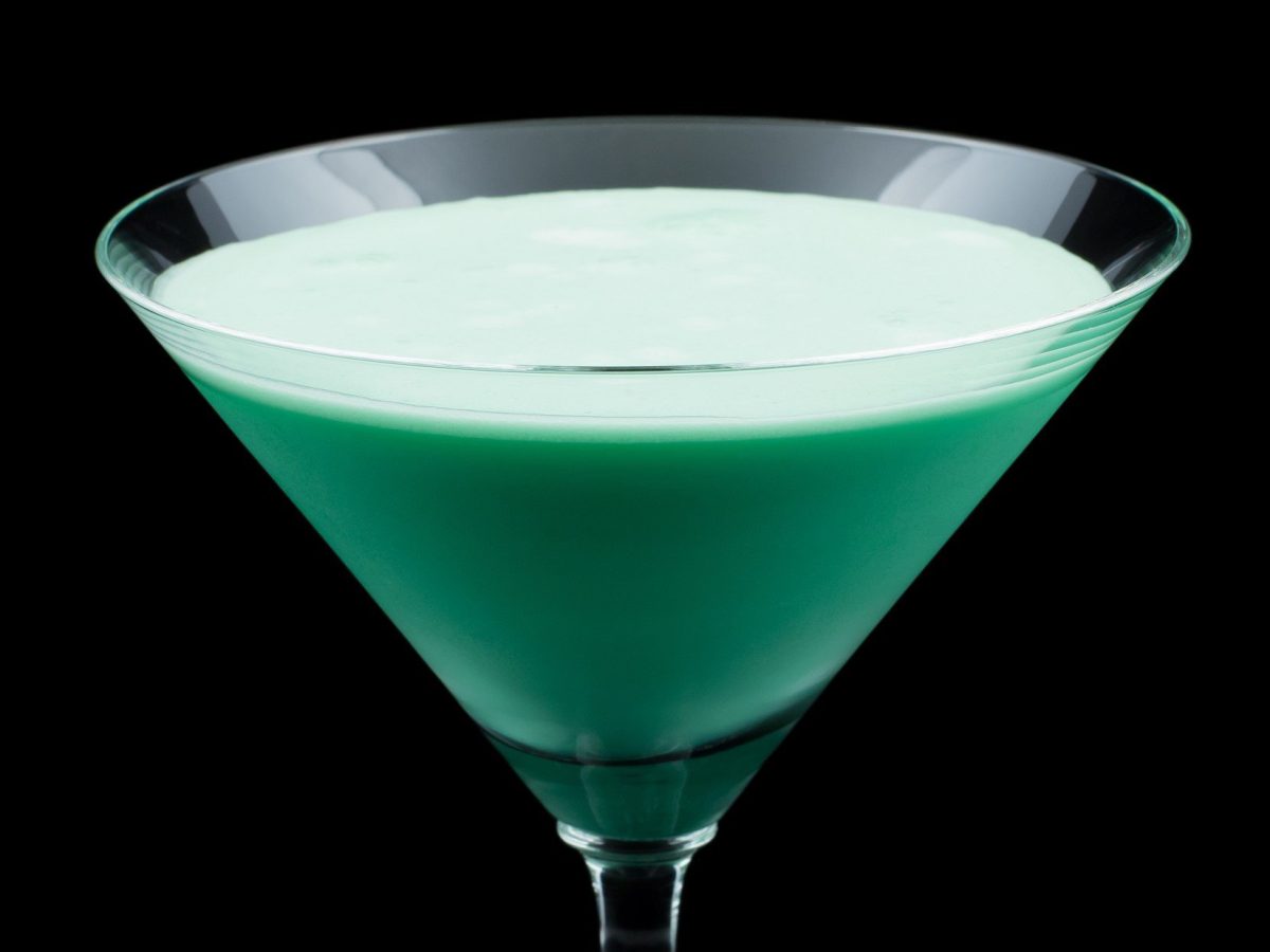 Grasshopper in einem Martini-Glas vor dunklem Hintergrund