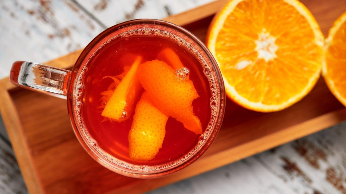 Hot Aperol in durchsichtigen Gläsern auf Holztablett