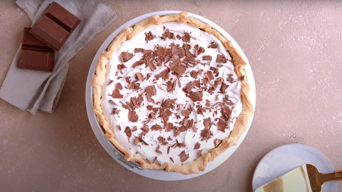 Französischer Seidenkuchen mit Schokocreme und Sahne auf weißem Teller.