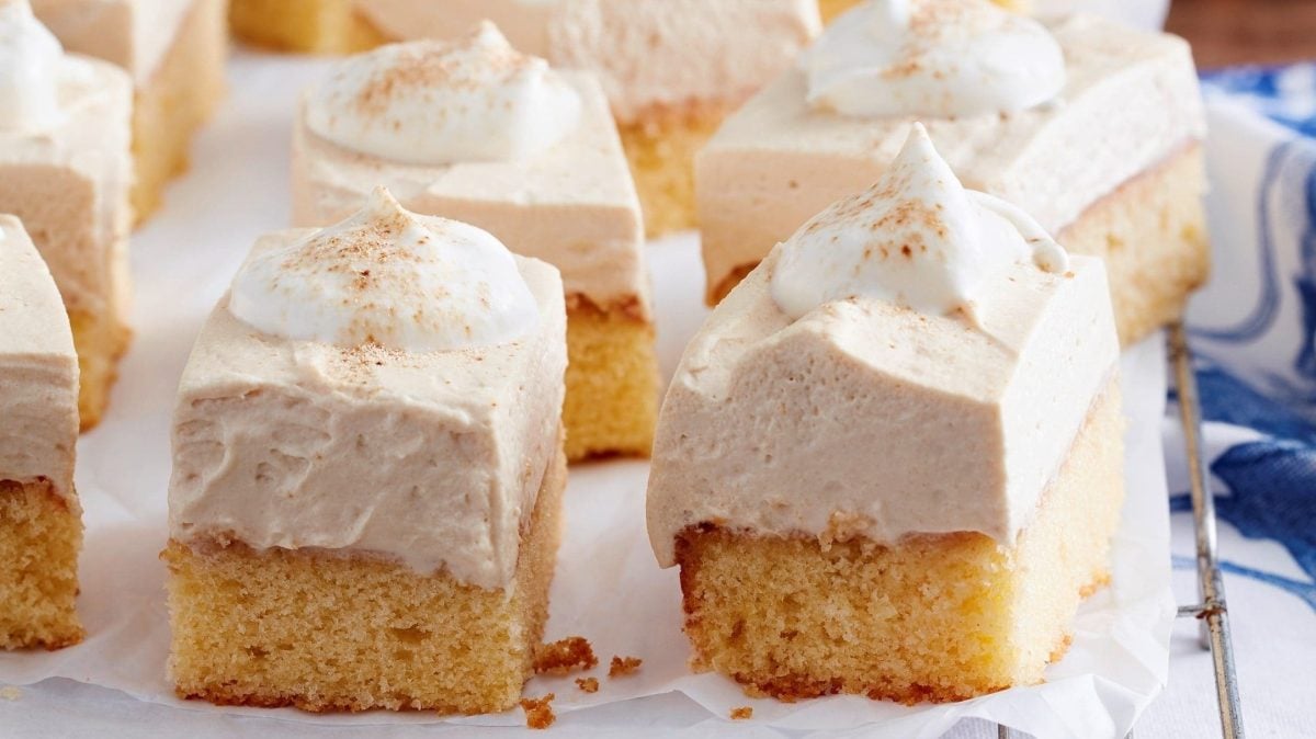 Unser Cappuccino-Creme-Kuchen liegt in Stücke geschnitten auf Backpapier aus.