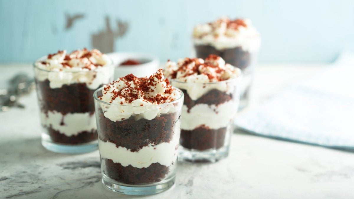 Mehrere Red Velvet Cakes im Glas auf einer Marmorplatte vor hellem Hintergrund.