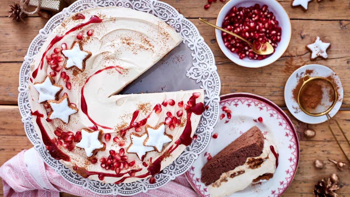 Ein Stück von unserer Zimtstern-Tiramisu-Torte liegt auf dem Teller, die restliche Torte auf der Tortenplatte.