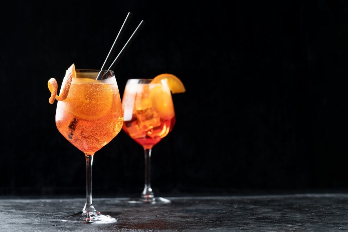 zwei Gläser mit Aperol Spritz in dunklem Ambiente