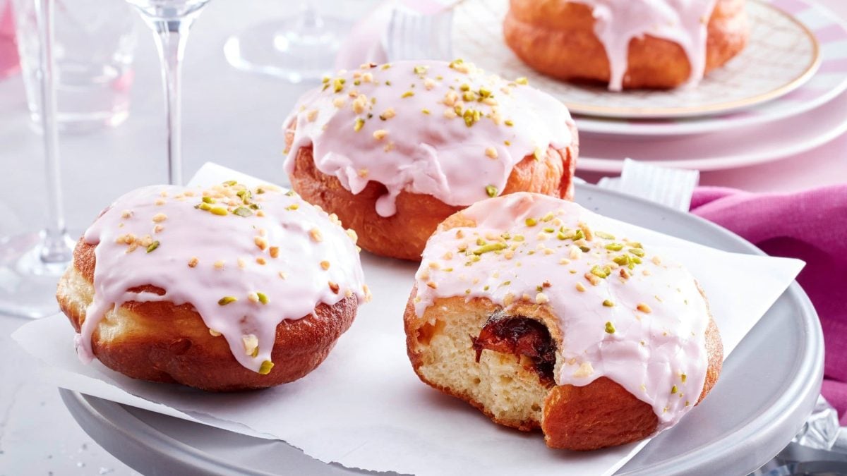 Berliner mit Zuckerguss auf Teller serviert.