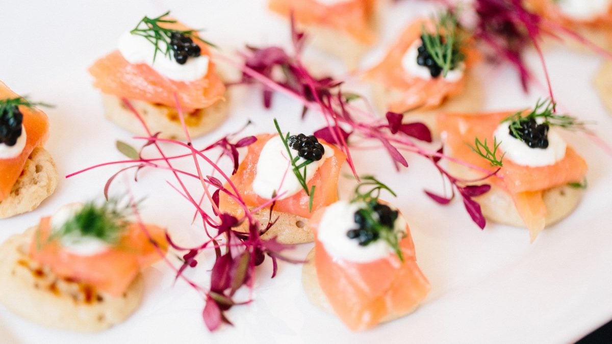 Canapes mit Lachs und Kaviar auf weißem Teller