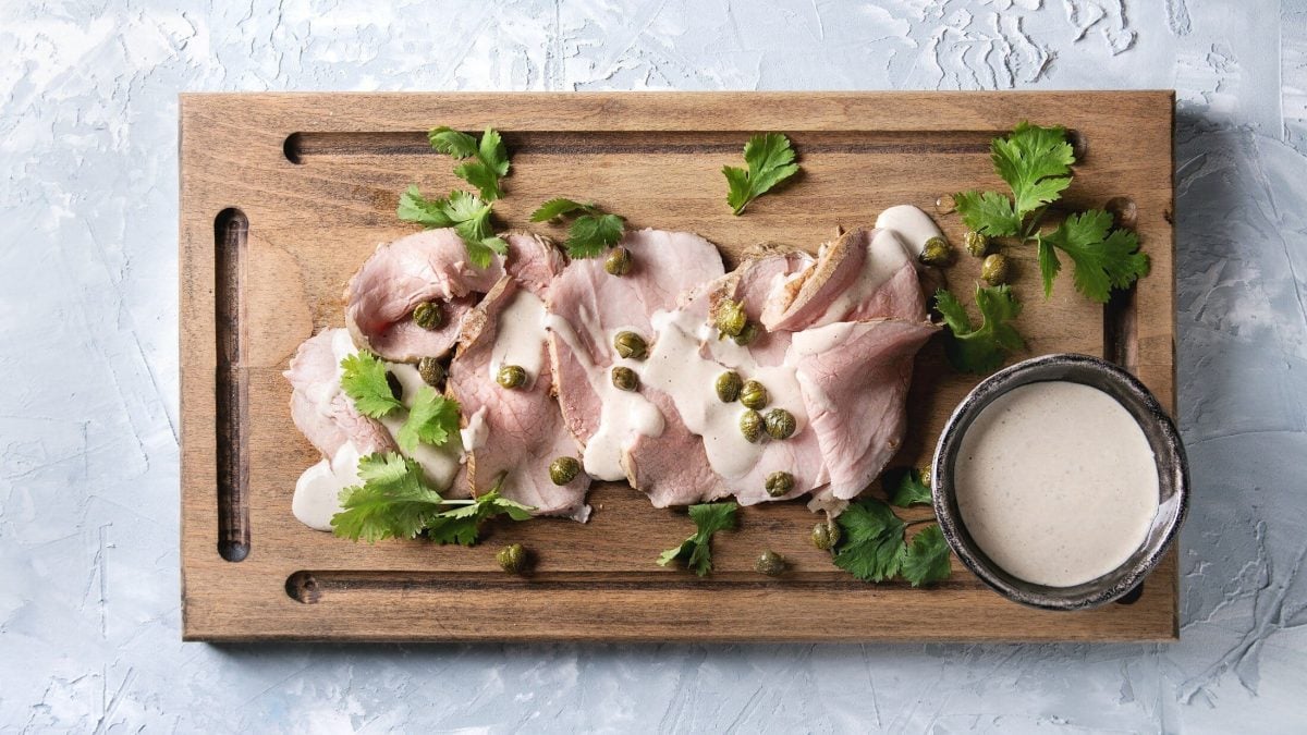 Vitello Tonnato auf Holbrett mit Kräutern