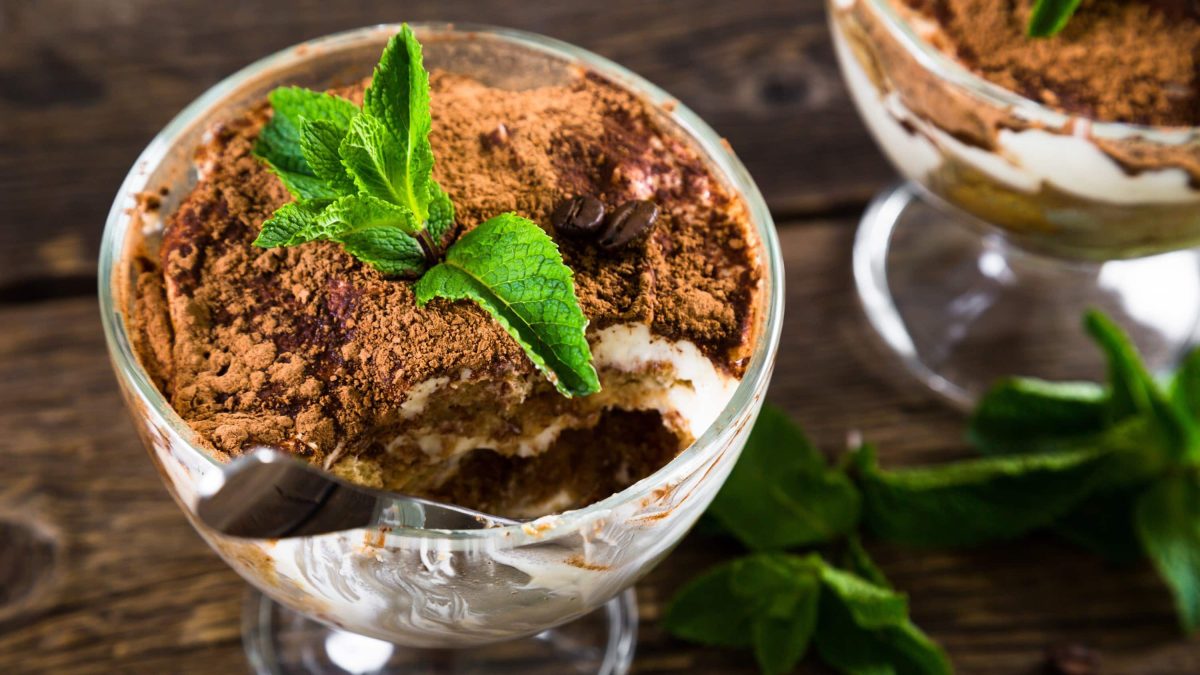 In kleinen Gläsern angerichtetes Tiramisu mit Bratäpfeln und Mascarpone, garniert mit frischem Pfefferminz