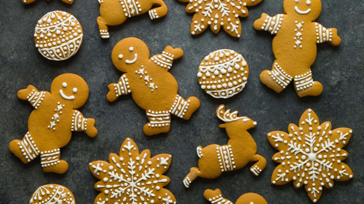 Verschiedene selbstgemachte Lebkuchen auf schwarzem Untergrund. Verziert mit weißem Zuckerguss.