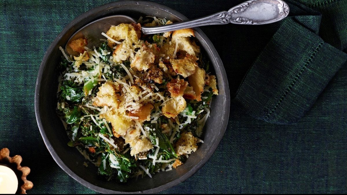 Draufsicht: Auf einem Teller ist Rahmgrünkohl mit Parmesan-Croûtons angerichtet.
