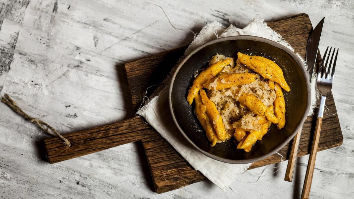Schupfnudeln in einer gusseisernen Pfanne mit Sauerkraut und Gewürzen