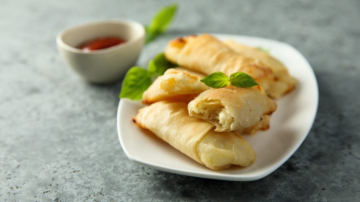 Gefüllter Börek auf weißem Teller mit einer Dip-Schale