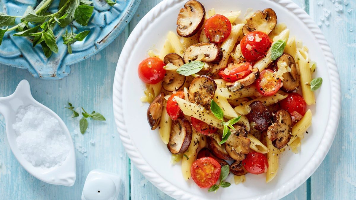 Oregano-Pilze mit Pasta auf Teller serviert.