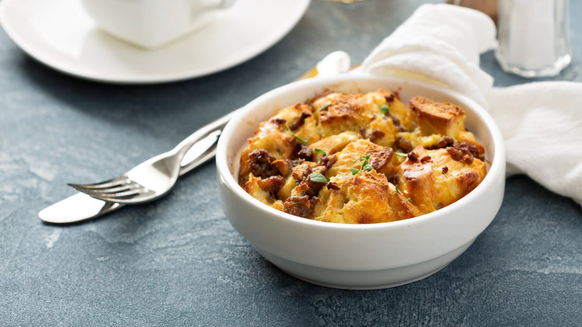 Schale mit Brotauflauf namens Strata mit Speck und Käse