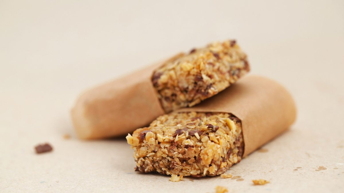 Zwei Flapjacks in Backpapier eingewickelt auf hellem Untergrund.