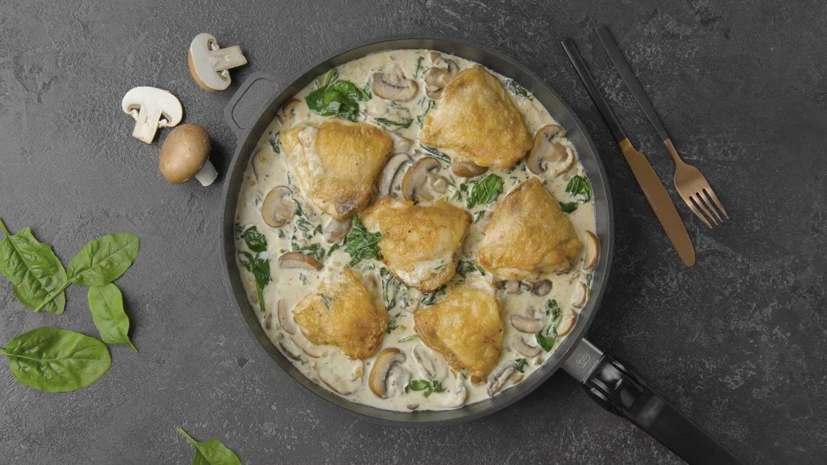 Vogelspersektive: In einer großen Pfanne Hühnchen in Spinat-Pilzrahm-Sauce angerichtet.