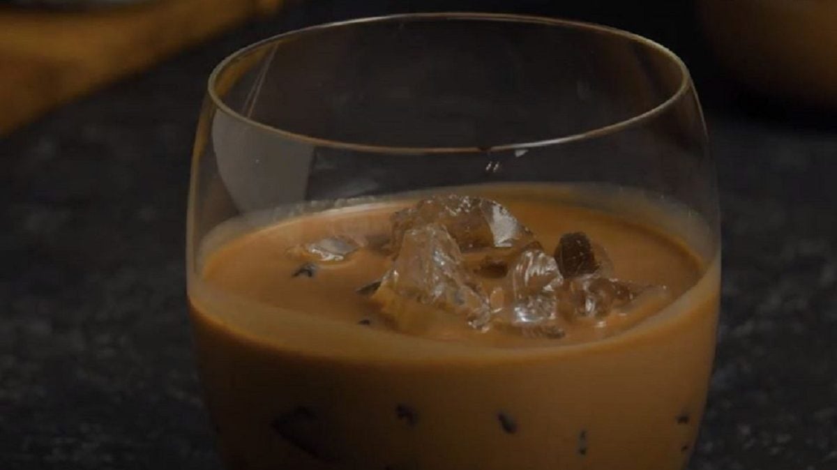 Ein Glas mit Nutella-Likör auf Eiswürfeln.