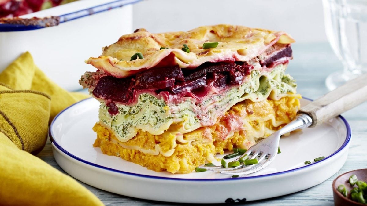 Ein Stück Regenbogen-Lasagne liegt auf einem weißen Teller.