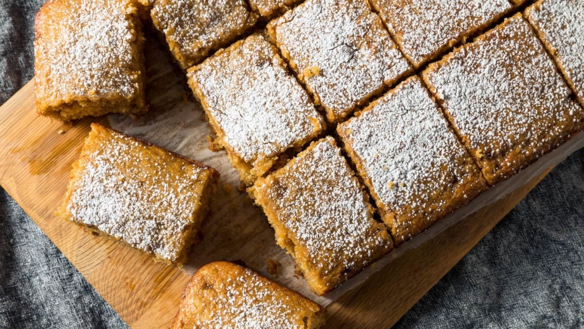 Apfelmuskuchen mit Puderzucker bestäubt auf Holzbrett