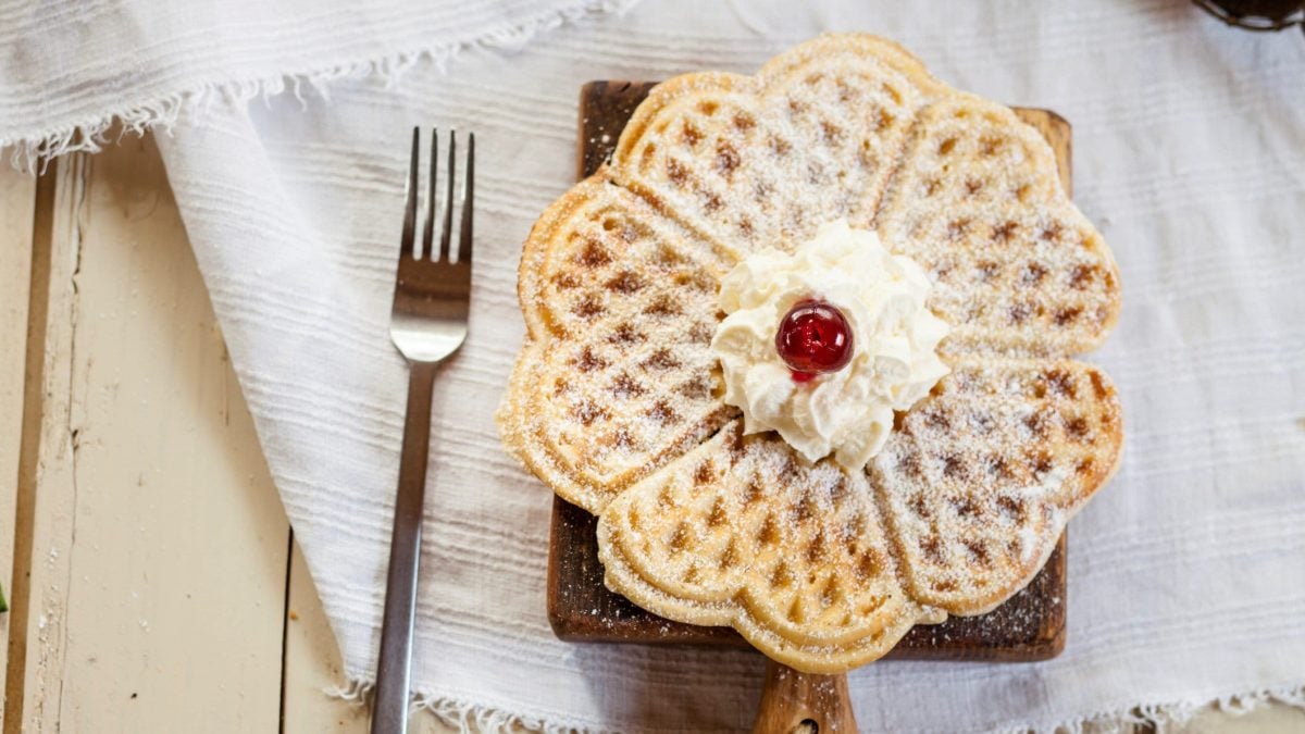 Mit Puderzucker bestäubte Waffeln auf Holzbrett